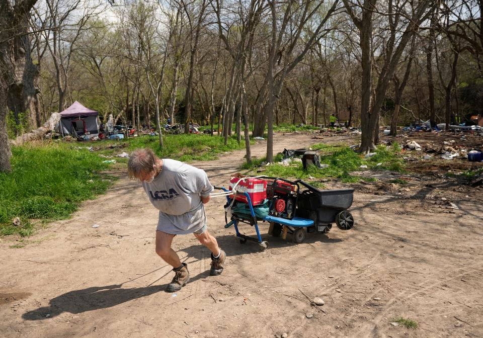 Kent Romines, who has been homeless for six years, pulls a cart with his belongings after he was removed from his campsite. “I don’t know where I’m going,” said Romines, 64.