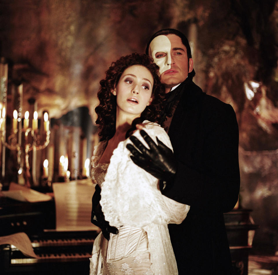 gerard butler and emmy rossum embracing as the phantom and christine in phantom of the opera