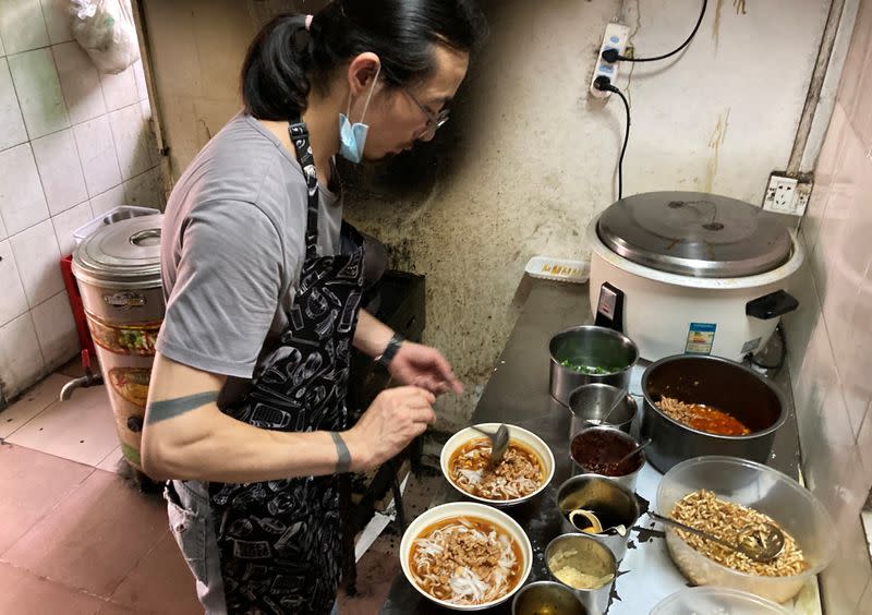 Noodles shop owner and a rock band singer Wang Zongxing makes noodles for customers at his restaurant in Shenzhen