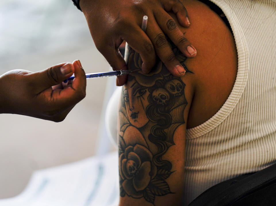 A young woman gets her shot of Russia's Sputnik V coronavirus vaccine during a vaccination drive at University Stadium in Mexico City, Friday, July 23, 2021. So far, about 42.4 million people have been vaccinated, according to the health ministry. That is about 47% of the adult population, and about 30% of the total population. (AP Photo/Fernando Llano)