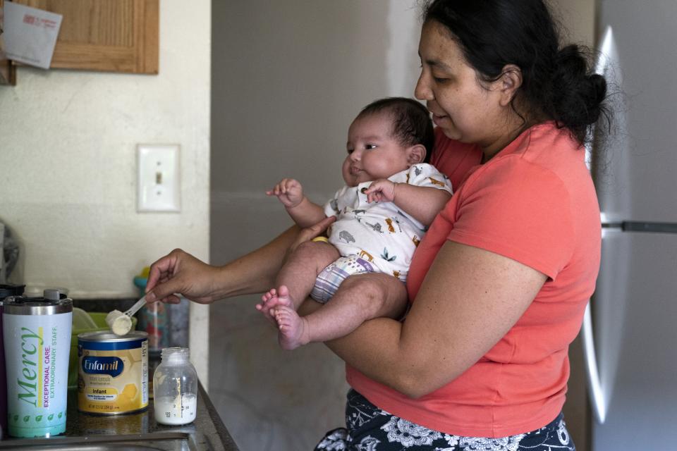 Yury Navas, 29, of Laurel, Md., scoops formula to make a bottle for her infant son, Ismael Galvaz, 2 months, with the only formula he can take without digestive issues, Enfamil Infant, from her dwindling supply of formula at their apartment in Laurel, Md., Monday, May 23, 2022. After this day's feedings she will be down to their last 12.5 ounce container of formula. Navas doesn't know why her breastmilk didn't come in for her third baby and has tried many brands of formula before finding the one kind that he could tolerate well, which she now says is practically impossible for her to find. To stretch her last can she will sometimes give the baby the water from cooking rice to sate his hunger. (AP Photo/Jacquelyn Martin)