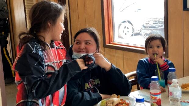 Carla Norwegian, centre, eats lunch with her three kids at the Snowshoe Cafe. Their family lost everything in the flood. 