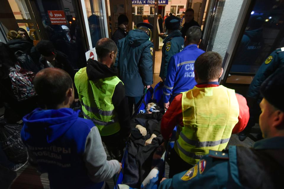 Volunteers and paramedics carry an elderly evacuee from Kherson into a hall upon evacuees arrival to Dzhankoi, Crimea, Thursday, Nov. 10, 2022. Russian Defense Minister Sergei Shoigu ordered a troop withdrawal from Kherson and nearby areas on Wednesday after his top general in Ukraine reported that a loss of supply routes during Ukraine's southern counteroffensive made a defense "futile."