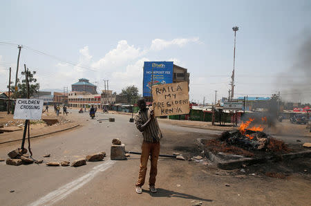 A supporter of Kenyan opposition leader Raila Odinga holds a sign in Kisumu, Kenya August 11, 2017. REUTERS/Baz Ratner