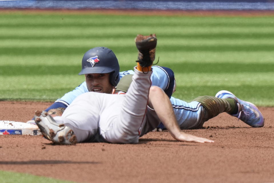 vToronto Blue Jays George Springer reaches back for the base on a successful steal attempt as Baltimore Orioles second baseman Adam Frazier (12) tries for the tag during the first inning of a baseball game in Toronto on Sunday, May 21, 2023. (Frank Gunn/The Canadian Press via AP)