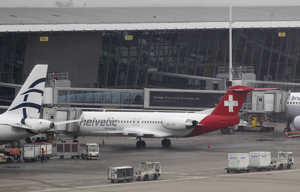 FILE - Baggage carts make their way past a Helvetic Airways aircraft from which about $50 million worth of diamonds were stolen on the tarmac of Brussels international airport, on Feb. 19, 2013. A decade after a brazen diamond heist at Brussels airport, it looks like a near-perfect crime. While one person was convicted to five years in prison and a small part of the loot — estimated at $50 million in 2013 — was recovered, the four remaining suspects were acquitted on appeal Wednesday March 8, 2023, leaving it unclear whether the mastermind will ever be found. (AP Photo/Yves Logghe, File)