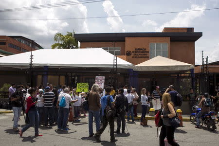 Protesters hold placards during a gathering in demand for medicines in Caracas, Venezuela August 27, 2015. REUTERS/Marco Bello