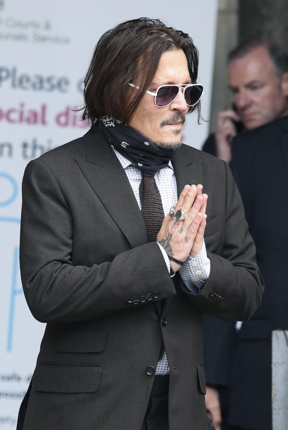 Actor Johnny Depp gestures as he arrives at the High Court to give evidence in his libel case, in London, Wednesday July 15, 2020. Depp is suing News Group Newspapers, publisher of The Sun, and the paper’s executive editor, Dan Wootton, over an April 2018 article that called him a “wife-beater.” The Sun’s defense relies on a total of 14 allegations by Amber Heard of Depp’s violence. He strongly denies all of them. ( Jonathan Brady/PA via AP)