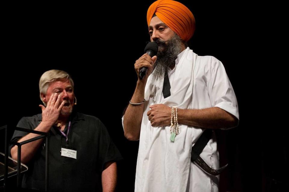 Spiritual Life Center minister the Rev. Michael Moran, left, wipes his eye while listening to Gurtej Singh Cheema during a service for the Spiritual Life Center on the Sacramento City College campus in 2012. Moran, who founded the congregation with his late wife, the Rev. Faith Clark Moran, died March 24 at his home in Idaho. He was 75. Randall Benton/Sacramento Bee file