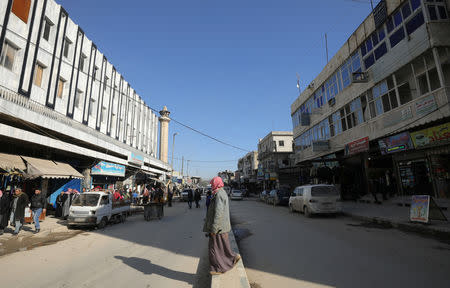 People walk near the Manbij Municipality building in Manbij city, Syria December 29, 2018. Picture taken December 29, 2018. REUTERS/Rodi Said