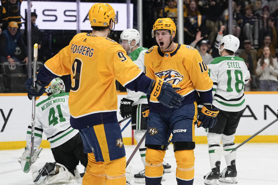 Nashville Predators left wing Filip Forsberg (9) congratulates center Colton Sissons (10) after a goal against the Dallas Stars during the second period of an NHL hockey game Saturday, Dec. 23, 2023, in Nashville, Tenn. (AP Photo/George Walker IV)