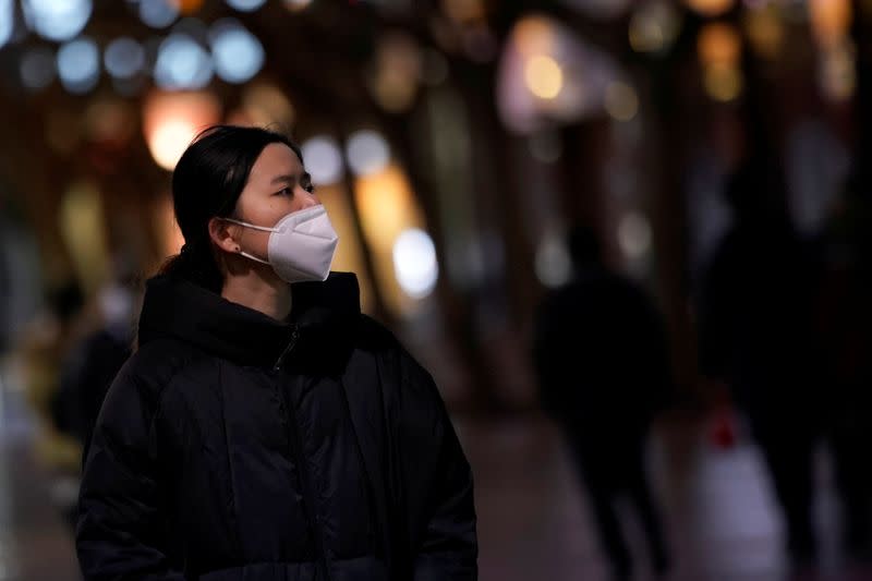 A woman wearing a mask is seen on a street in Shanghai