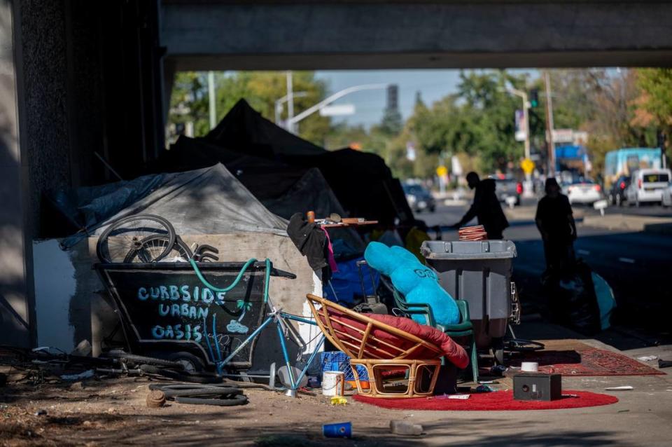 A sign that reads “curbside urban oasis” welcomes people walking on Alhambra Boulevard under the Highway 99 underpass on Wednesday, Oct. 5, 2022. Lawmakers and Gov. Gavin Newsom declined to provide another round of state homelessness grant funding in the California budget.