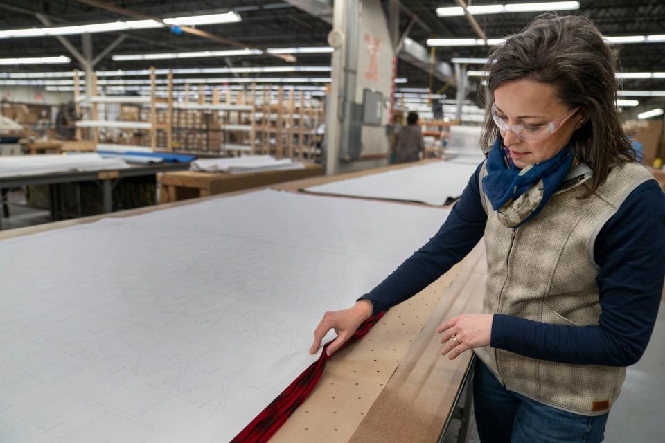 CEO of Jacquart Fabric Products, home of Stormy Kromer, Gina Jacquart Thorsen, 48, checks on fabric before it will be cut to create hats in the Ironwood warehouse on Thursday, Jan. 4, 2024. "The people are the best part of coming here," said Thorsen of her dedicated 70 employees. "It's more than a hat," she added about the passion customers have for the hats and products they sew, including the vest she is wearing. Her grandfather Robert Jacquart started the family fabric business in 1958 then passed it to her father and her father passed the lead to Thorsen in June 2022.