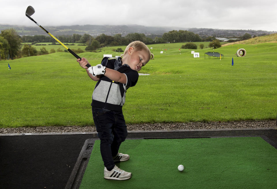 Three-year-old George Hughes can already hit the ball 100 years. (Credit: SWNS) George Hughes (3).  A talented toddler who has already been playing golf half his life has been hailed the next Rory McIlroy because of his exceptional skill off the tee. See SWNS story SWLEgolf.  Little George Hughes can already drive, pitch and putt the ball despite only celebrating his third birthday last month.   His longest shot to date is 100 yards and earlier this year he completed an entire hole for the first time in 11 shots. The little lad regularly takes to the course with his own set of clubs and a tiny glove but he can't wear golf shoes or clothing yet as no brand make them in his size.  George's golf mad granddad Tony Sedgwick, 48, sparked the youngster's love of the game when he bought him a set of plastic toy clubs 18 months ago. "It's really fun going to the golf range and to the golf course with my granddad," George said. "I love whacking the golf ball."  