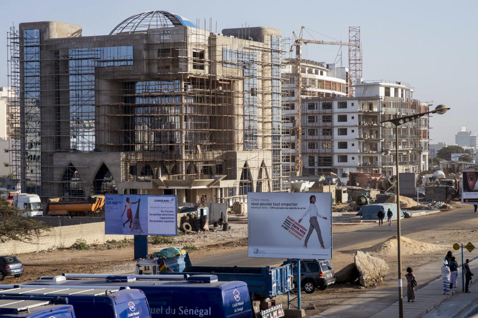 In this photo taken on Tuesday, Feb. 11, 2014, a building under construction in the Ouest Foire neighborhood of Dakar, Senegal. President Macky Sall successfully ran on a campaign to lower living costs and now a new law mandates across-the-board rent reductions in Senegal, although everybody knows enforcement will be tricky and some landlords will defy the threat of prison sentences as they fail to comply with the reductions after decades of increases. (AP Photo/Sylvain Cherkaoui)