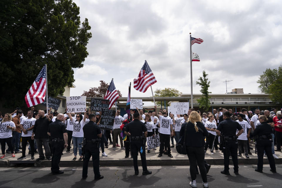 People protesting a planned Pride month assembly stand outside Saticoy Elementary School in Los Angeles, Friday, June 2, 2023. Police officers separated groups of protesters and counter protesters Friday outside the elementary school that has become a flashpoint for Pride month events across California. (AP Photo/Jae C. Hong)