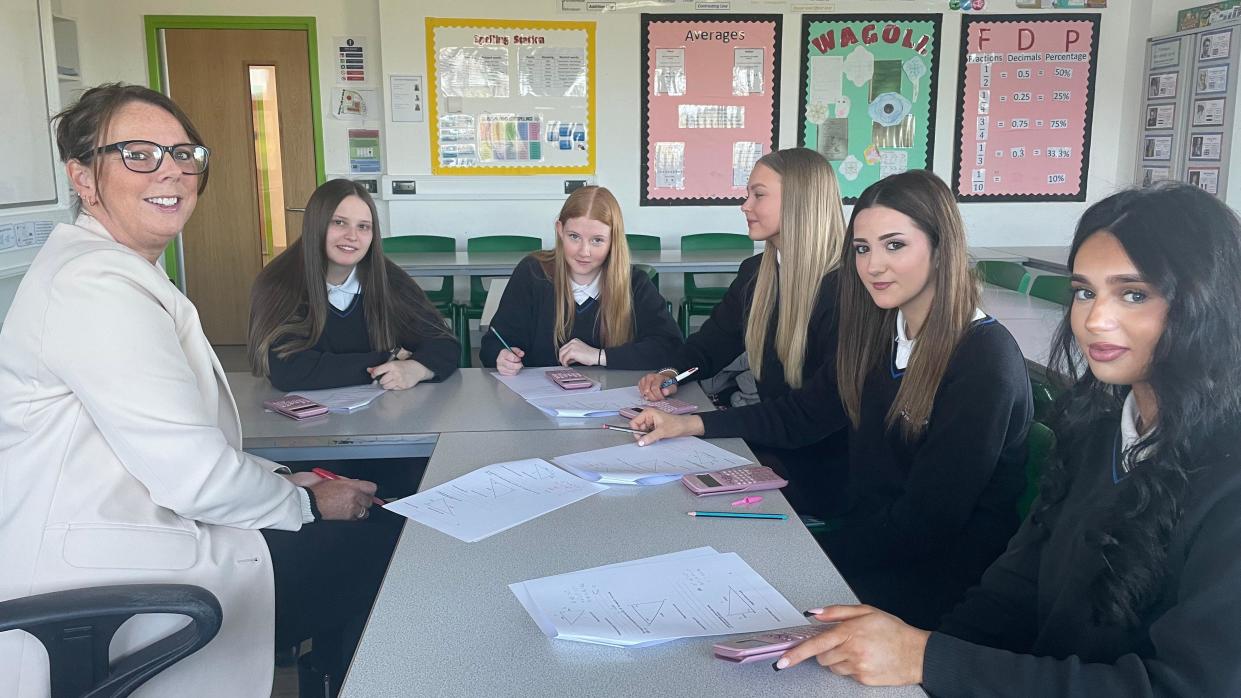 A teacher and small group of pupils in a classroom