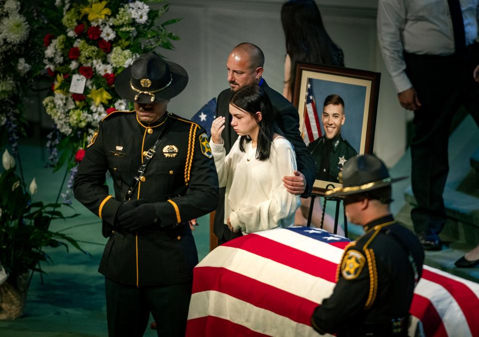 Wayne Lane and Maddix Lane, father and sister, of former Polk County sheriff's Deputy Blane Lane, walk by the casket during a funeral service at Victory Church in Lakeland on Tuesday.