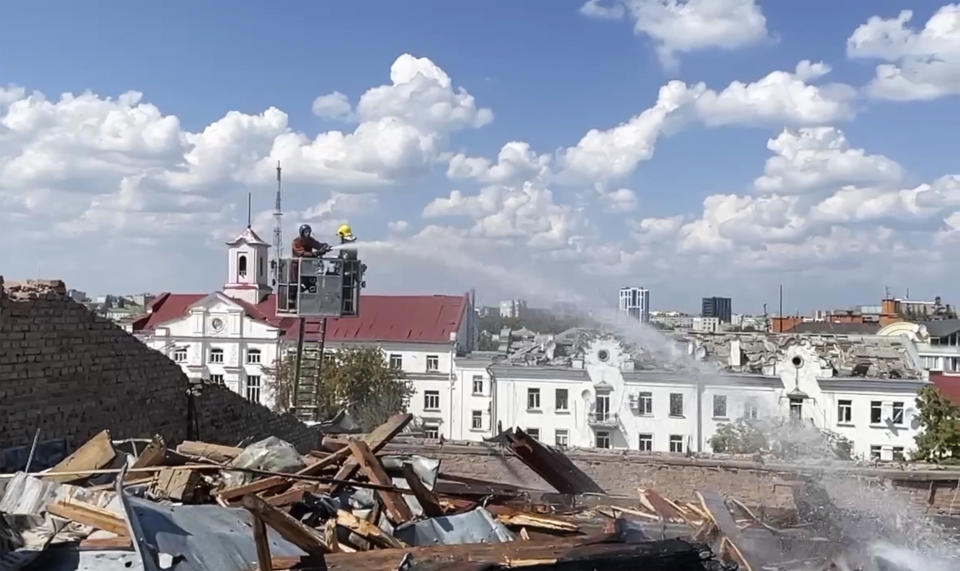 In this photo taken from video provided by the Ukrainian Emergency Service, firefighters work on a roof of the Taras Shevchenko Chernihiv Regional Academic Music and Drama Theatre damaged by Russian attack in Chernihiv, Ukraine, Saturday, Aug. 19, 2023. (Ukrainian Emergency Service via AP)
