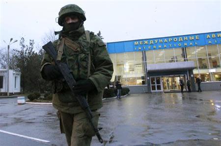 An armed man patrols at the airport in Simferopol, Crimea February 28, 2014. REUTERS/David Mdzinarishvili