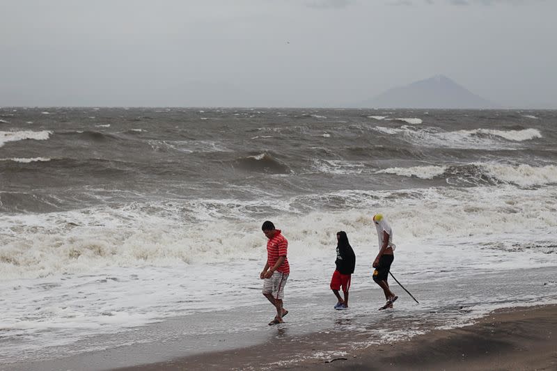 People walk along a beach as Storm Iota approaches, in Cedeno