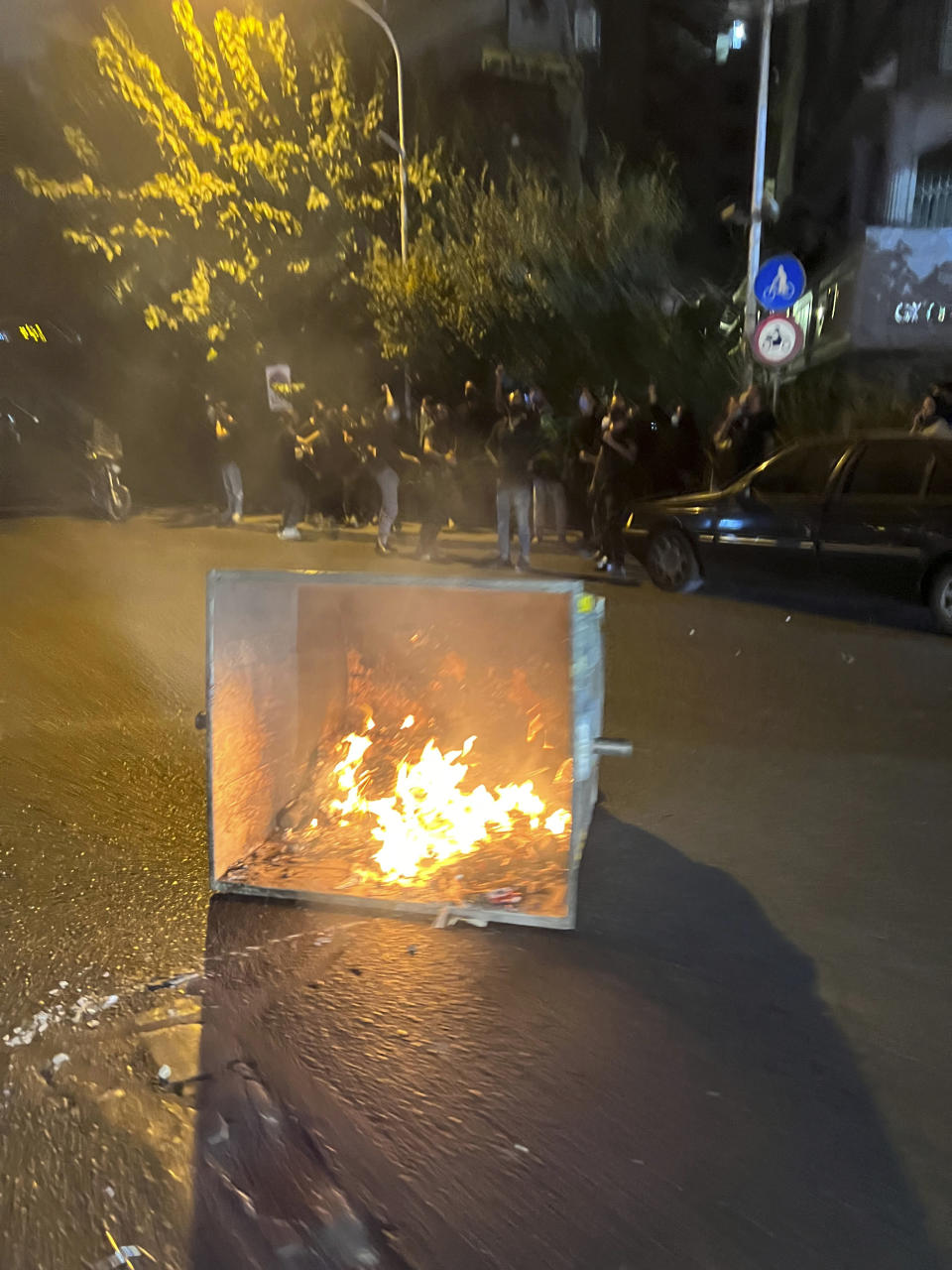 In this Tuesday, Sept. 20, 2022, photo taken by an individual not employed by the Associated Press and obtained by the AP outside Iran, a trash bin is burning during a protest over the death of a young woman who had been detained for violating the country's conservative dress code, in downtown Tehran, Iran. Iran faced international criticism on Tuesday over the death of a woman held by its morality police, which ignited three days of protests, including clashes with security forces in the capital and other unrest that claimed at least three lives. (AP Photo)