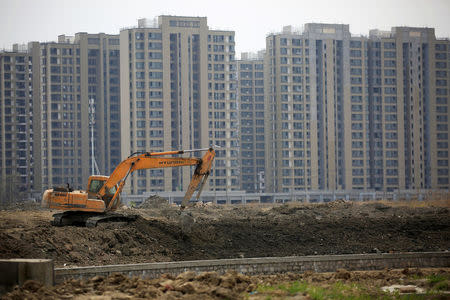 FILE PHOTO: An excavator is seen at a construction site of new residential buildings in Shanghai, China, March 21, 2016. REUTERS/Aly Song/File Photo