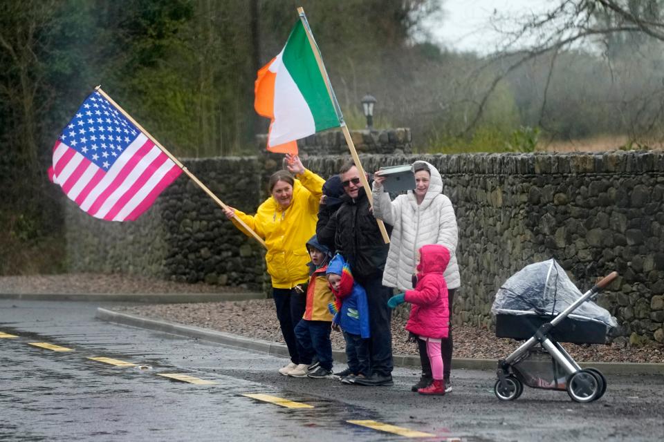 People watch as the motorcade for President Joe Biden drives past in County Louth, Ireland, Wednesday, April 12, 2023.