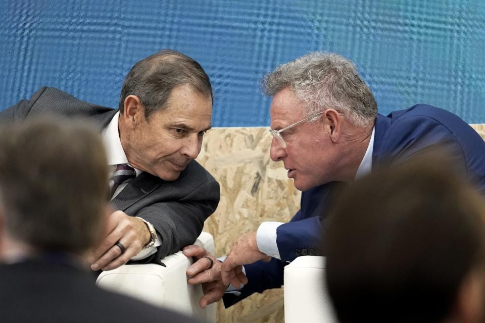 U.S. Rep. John Curtis, of Utah, left, and Rep. Scott Peters, D-Calif., talk during an event at the COP28 United Nations Climate Summit on Dec. 9, 2023, in Dubai, United Arab Emirates. | Joshua A. Bickel, Associated Press