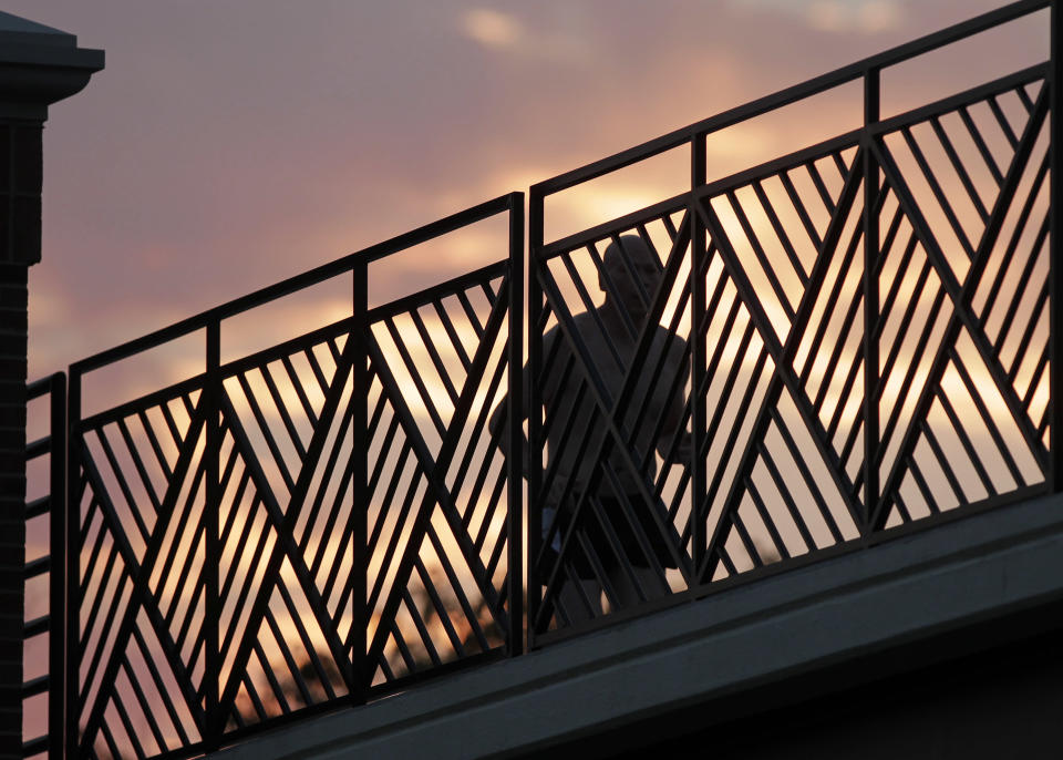 A runner makes his way across a bridge on the Monon Trail in Carmel, Ind., as the sun rises Thursday, June 28, 2012. Temperatures are expected to reach 100 degree in Central Indiana later in the day. (AP Photo/Michael Conroy)