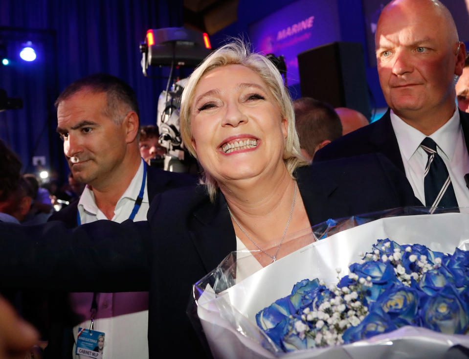 <p>Far-right leader and candidate for the 2017 French presidential election, Marine Le Pen, surrounded by bodyguards, celebrates with supporters while holding a bunch of flowers after exit poll results of the first round of the presidential election were announced at her election day headquarters in Henin-Beaumont, northern France, Sunday, April 23, 2017. Polling agency projections show far-right leader Marine Le Pen and centrist Emmanuel Macron leading in the first-round French presidential election. (AP Photo/Frank Augstein) </p>