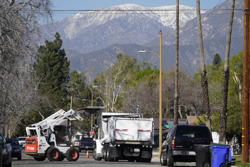 Crews remove damaged concrete sidewalks in Upland, Calif., on Monday, Jan. 24, 2022. After estimating a loss in revenue in the early months of the pandemic in 2020, city officials say Upland is now doing well financially, boosted partly by federal pandemic aid. The city plans to use part of that aid to repave parking lots and repair hundreds of sections of sidewalks. (AP Photo/Damian Dovarganes)