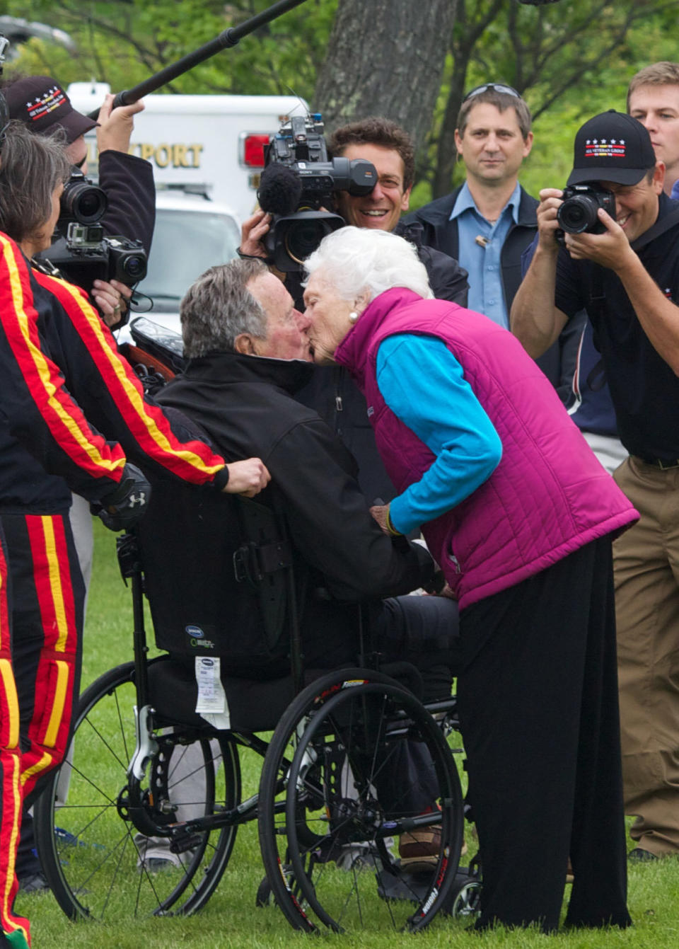 Barbara Bush greets her husband with a kiss after his successful skydive down to St. Anne's Episcopal Church on June 12, 2014, in Kennebunkport, Maine.