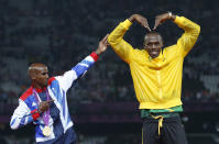 Jamaica's Usain Bolt (R) celebrates with Britain's Mo Farah on the podium after each receiving gold medals, Bolt for men's 4x100m relay and Farah for men's 5000m at the victory ceremony at the London 2012 Olympic Games at the Olympic Stadium August 11, 2012. REUTERS/Eddie Keogh (BRITAIN - Tags: SPORT OLYMPICS SPORT ATHLETICS TPX IMAGES OF THE DAY) 