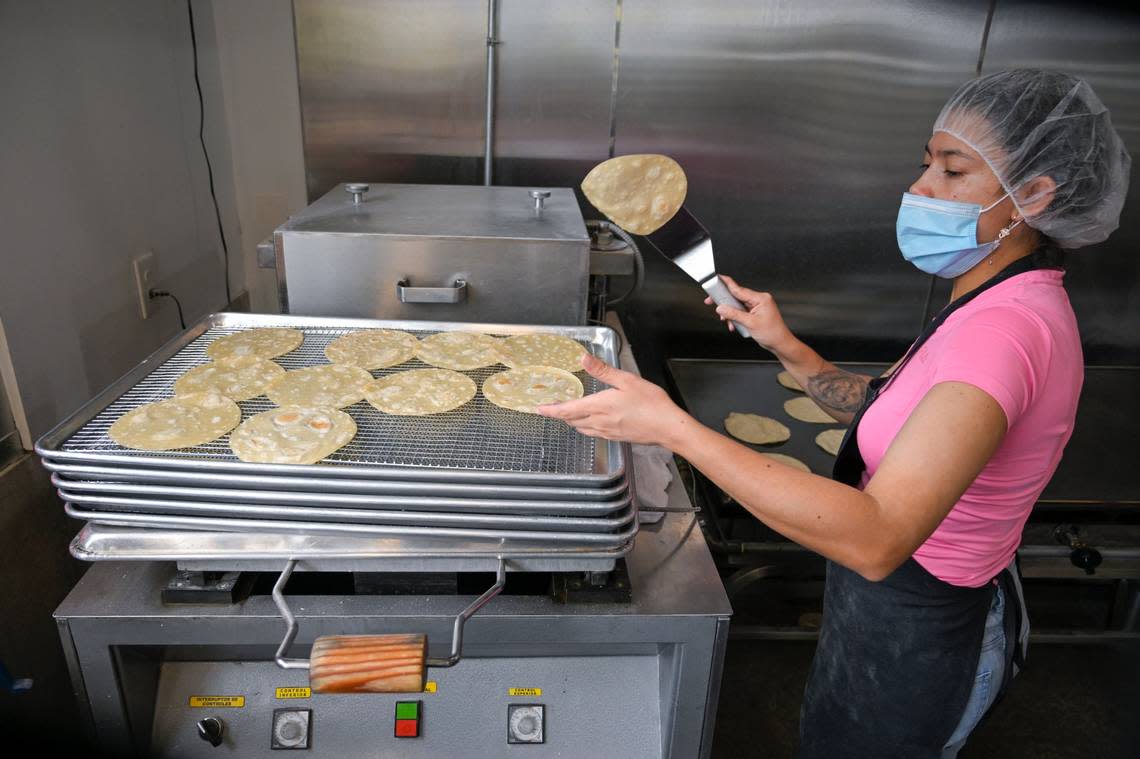 Diana Forero flips a tortilla onto a cooling rack before it’s packaged up and sent out to customers.