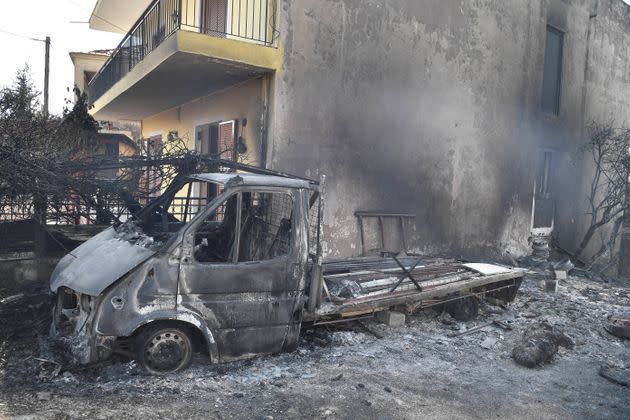 The remains of a van sits among burned trees and rubble as Greece swelters in a record-breaking heatwave. (Photo: LOUISA GOULIAMAKI via AFP via Getty Images)