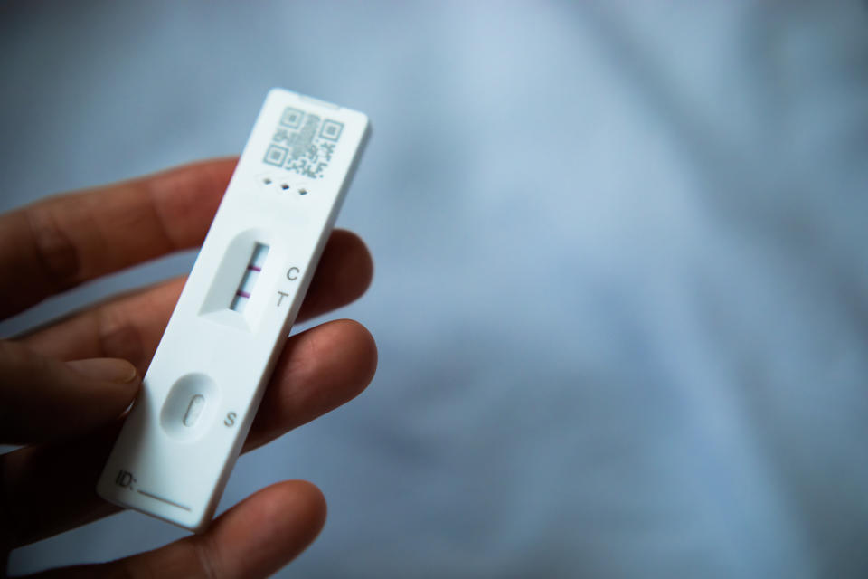 Positive Cassette rapid test for COVID-19. Close-up shot of woman's hand holding a negative test device.