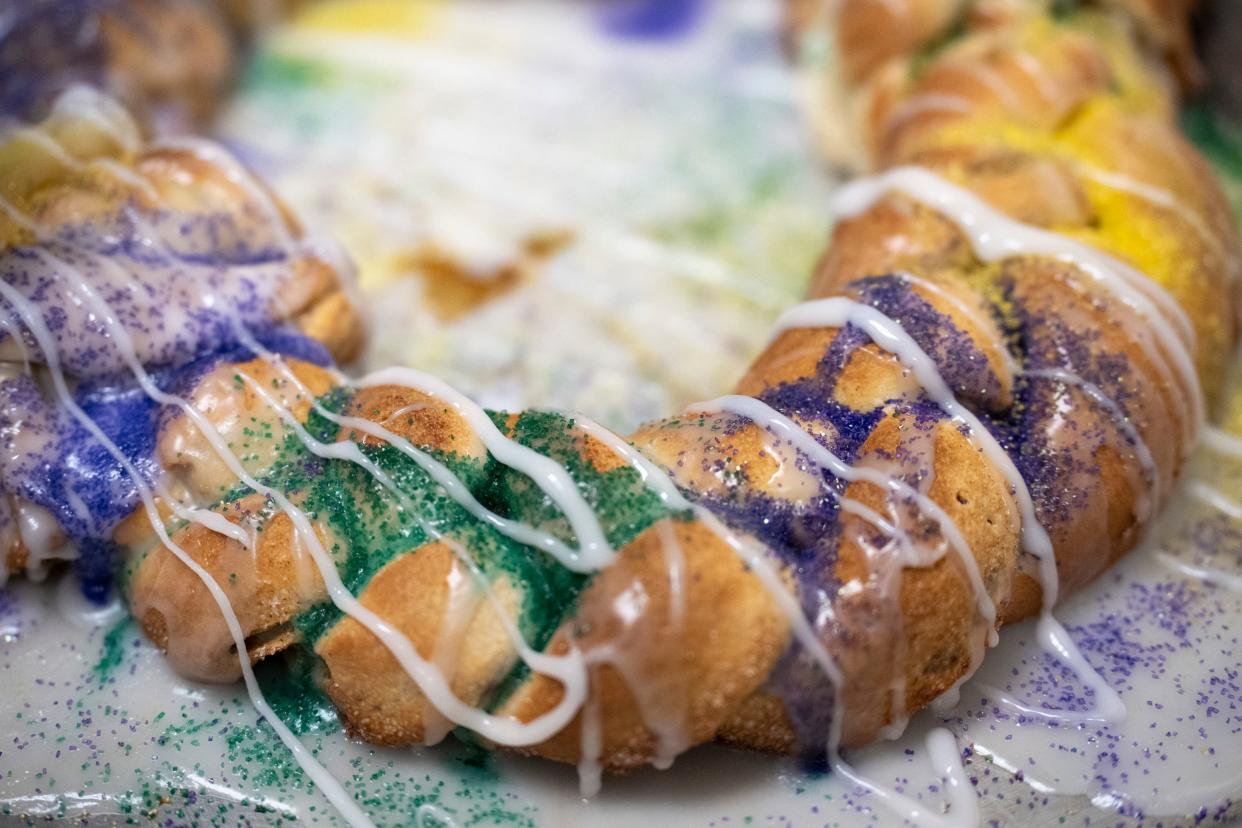 Different colored sugars are dashed onto a freshly baked king cake inside of Way Down Yonder Beignets & Coffee on Feb. 16.