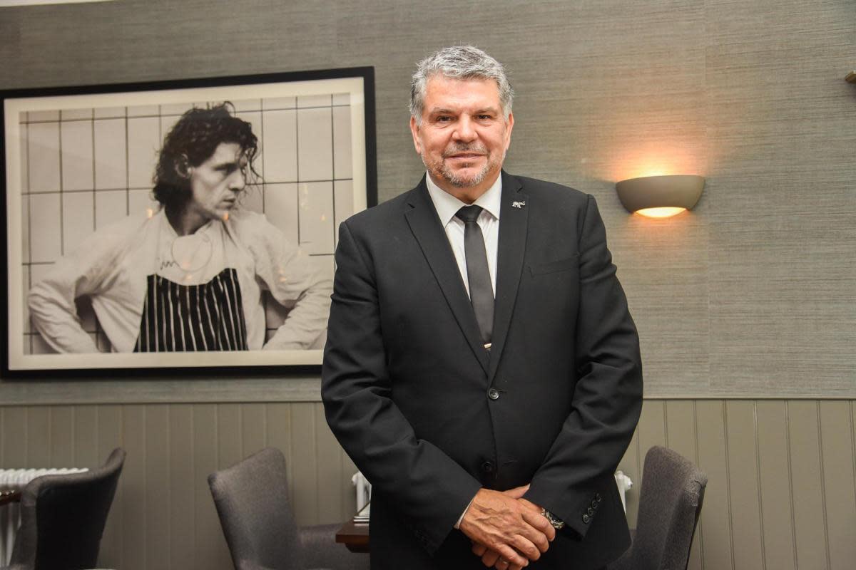 Andrew Vales at Hotel Coco with a photo of chef Marco Pierre White in the background <i>(Image: Charlotte Bond)</i>