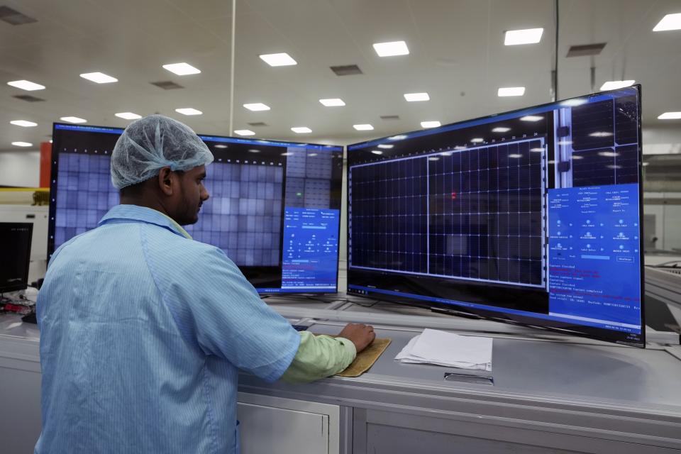 An operator inspects an electric image while producing solar panels at Premier Energies Solar on the outskirts of Hyderabad, India, Wednesday, Jan. 25, 2023. Solar developers in India fear that a tax meant to encourage Indian manufacture of solar components will slow down the installation of solar power this year. (AP Photo/Mahesh Kumar A.)