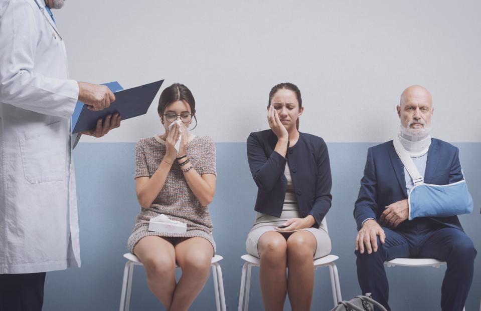 People in a waiting room showing various signs of illness with a medical professional holding a chart