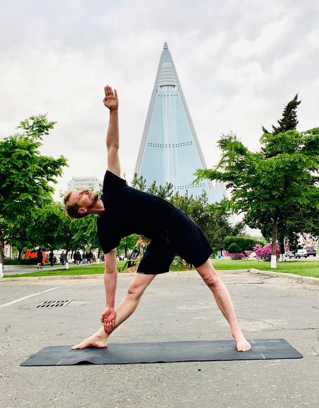 Swedish Ambassador Joachim Bergstrom practices yoga near the Ryugyong Hotel in Pyongyang