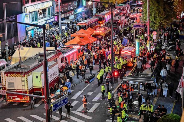 FOTO: Espectadores, policías y personal médico se reúnen después de que decenas resultaron heridas en una estampida después de que la gente se aglomerara en las estrechas calles del barrio de Itaewon para celebrar Halloween en Seúl, Corea del Sur, el 30 de octubre de 2022. (Jung Yeon-je/AFP vía Getty Images)