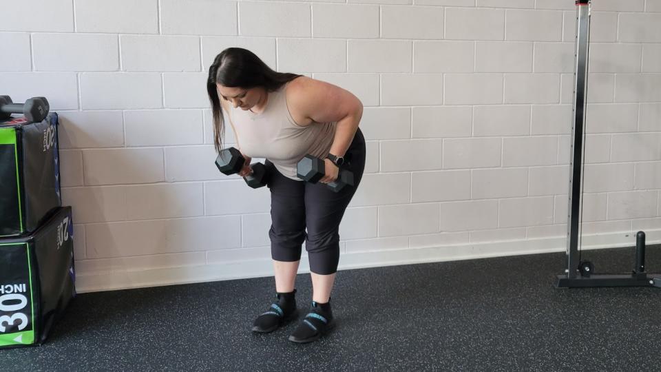 Personal trainer Rebecca Stewart performs a dumbbell dual row