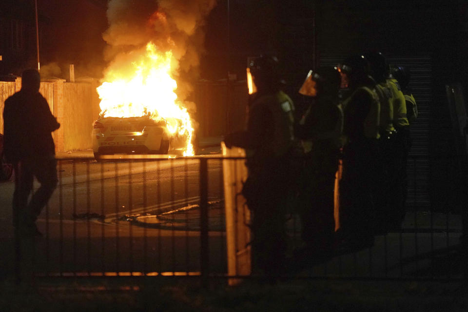 Una patrulla de policía arde mientras agentes se despliegan en las calles de Hartlepool, Inglaterra, tras una violenta protesta tras el asesinato de tres niñas que fueron apuñaladas mortalmente en el noroeste de Inglaterra, el miércoles 31 de julio de 2024. Grupos de extrema derecha buscan provocar ira por el ataque que han tratado de vincular, sin pruebas, con inmigrantes. (Owen Humphreys/PA vía AP)