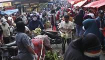 People shop in preparation of the upcoming Eid al-Fitr holiday that marks the end of the holy fasting month of Ramadan amid fears of the new coronavirus outbreak at a market in Jakarta, Indonesia, Friday, May 22, 2020. (AP Photo/Achmad Ibrahim)