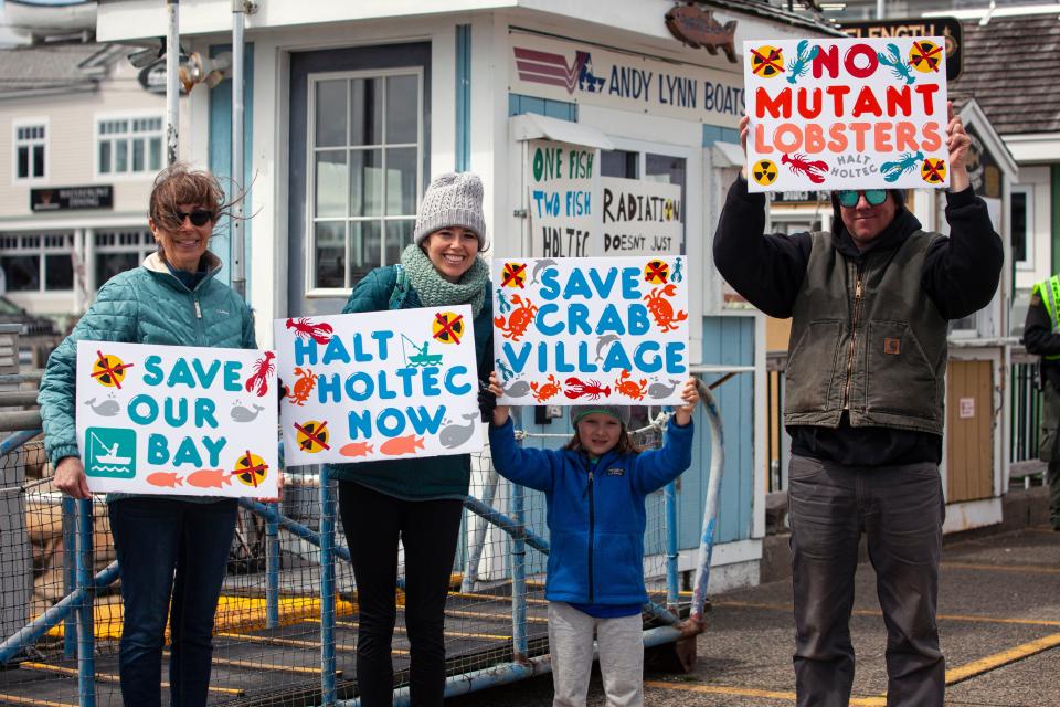 From left, Michele Hopkins, Sarah Hopkins, Quinn Cavicchi and Garth Cavicchi, of Plymouth, holding signs during the rally against Holtec releasing wastewater into Cape Cod Bay in Plymouth from the decommissioned Pilgrim Nuclear Power Station on Saturday, April 9, 2022.