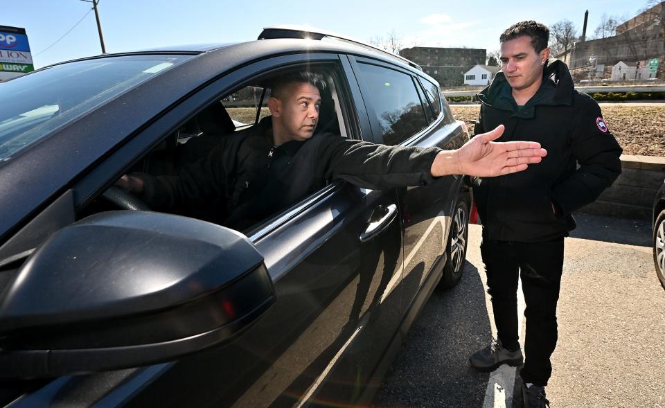 Interpreter Rony DaSilva makes sure Washington Gonsalves has his hand signals down before taking a road test at the CMSC Driving School road test site in Framingham.