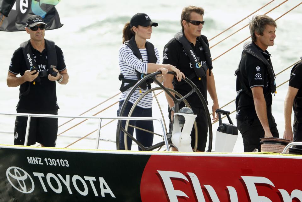 Catherine (2nd L), the Duchess of Cambridge, steers an America's Cup yacht as she sails on Auckland Harbour April 11, 2014. Britain's Prince William and his wife Kate are undertaking a 19-day official visit to New Zealand and Australia with their son George. REUTERS/Phil Noble (NEW ZEALAND - Tags: ROYALS TPX IMAGES OF THE DAY)